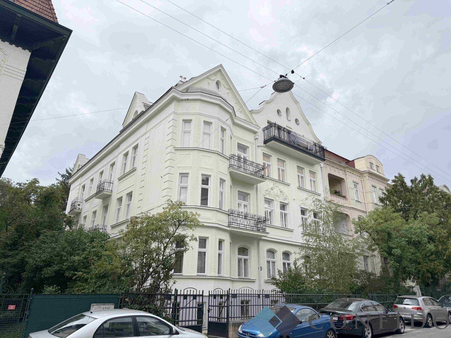 Historisches Gebäude mit eleganter Fassade, vielen Fenstern und Balkonen.