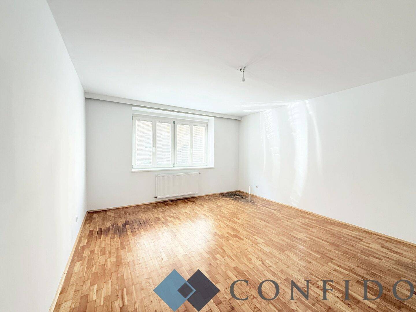 Ruhiges Schlafzimmer mit Parkettboden und Fenster, bietet eine angenehme Atmosphäre zum Entspannen.