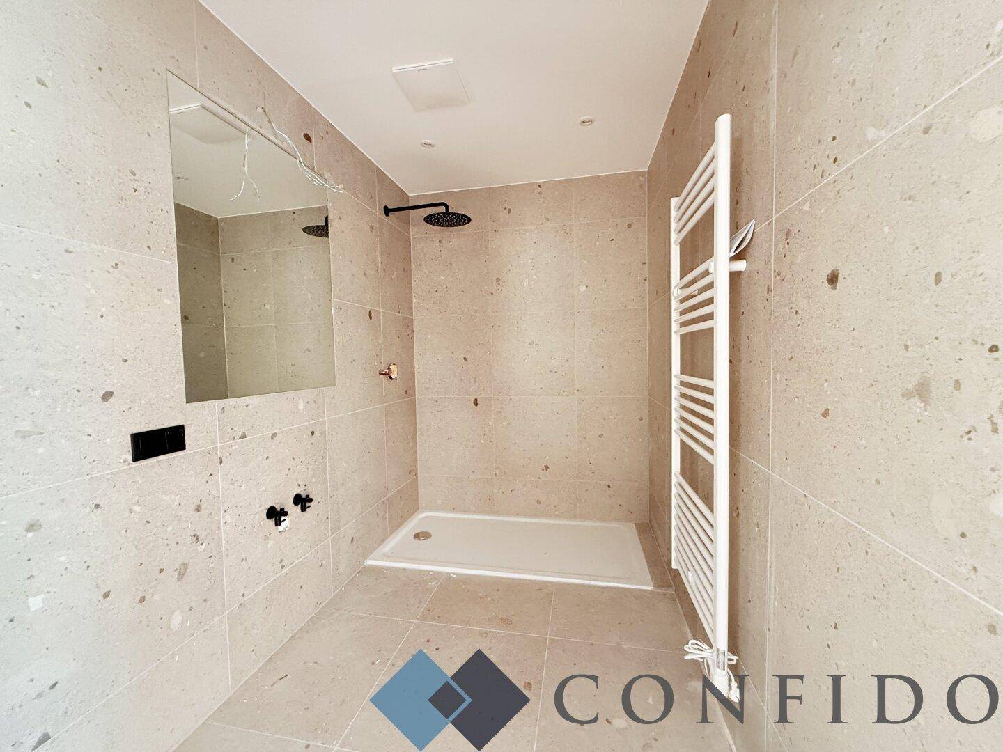 Modernes Badezimmer mit großformatigen Fliesen, Regendusche und Handtuchheizkörper.