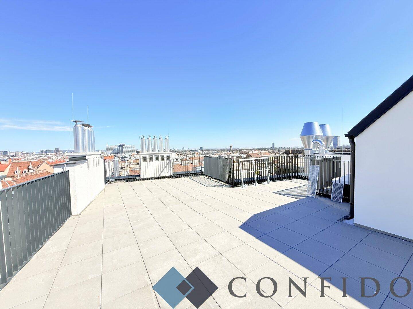Weitläufige Dachterrasse mit moderner Brüstung und Panoramablick über die Stadtlandschaft.