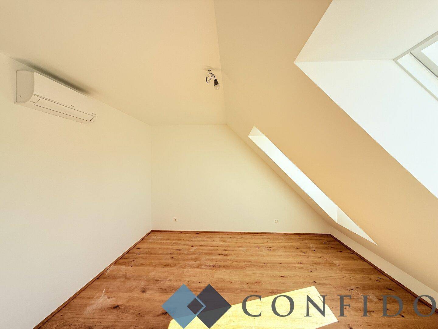 Gemütliches Schlafzimmer mit Holzboden, Dachschräge und Dachfenster, ausgestattet mit Klimaanlage.