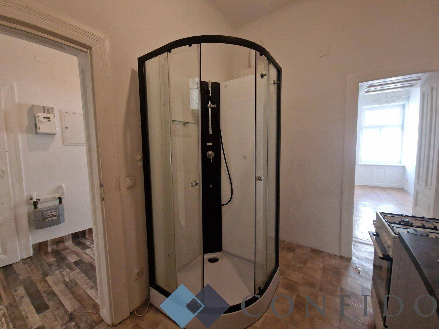 Ungewöhnlicher Raum mit einer Duschkabine und Blick auf angrenzende Bereiche.