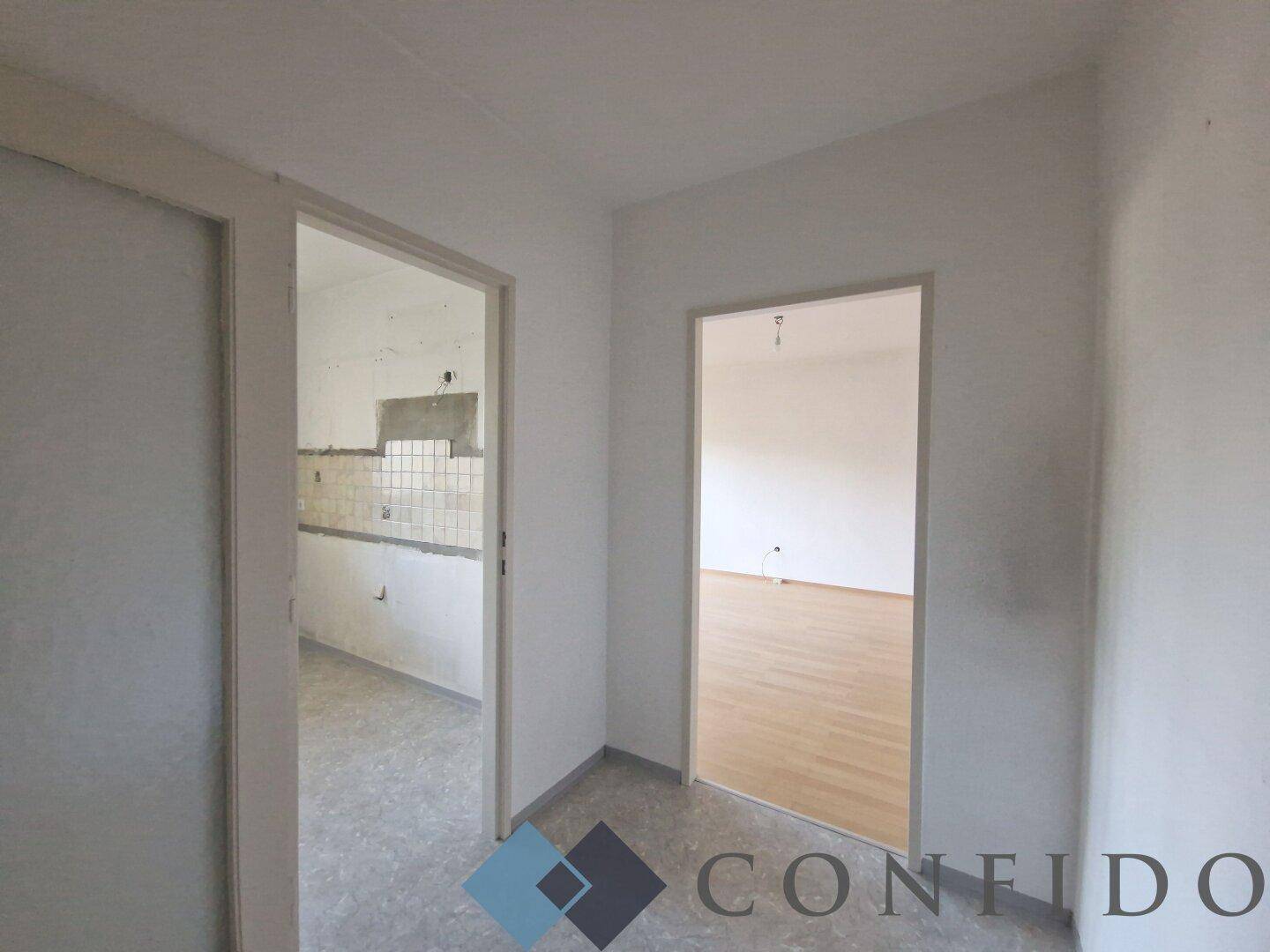 Flur mit Blick in die Küche und ein weiteres Zimmer, bietet gute Raumaufteilung.