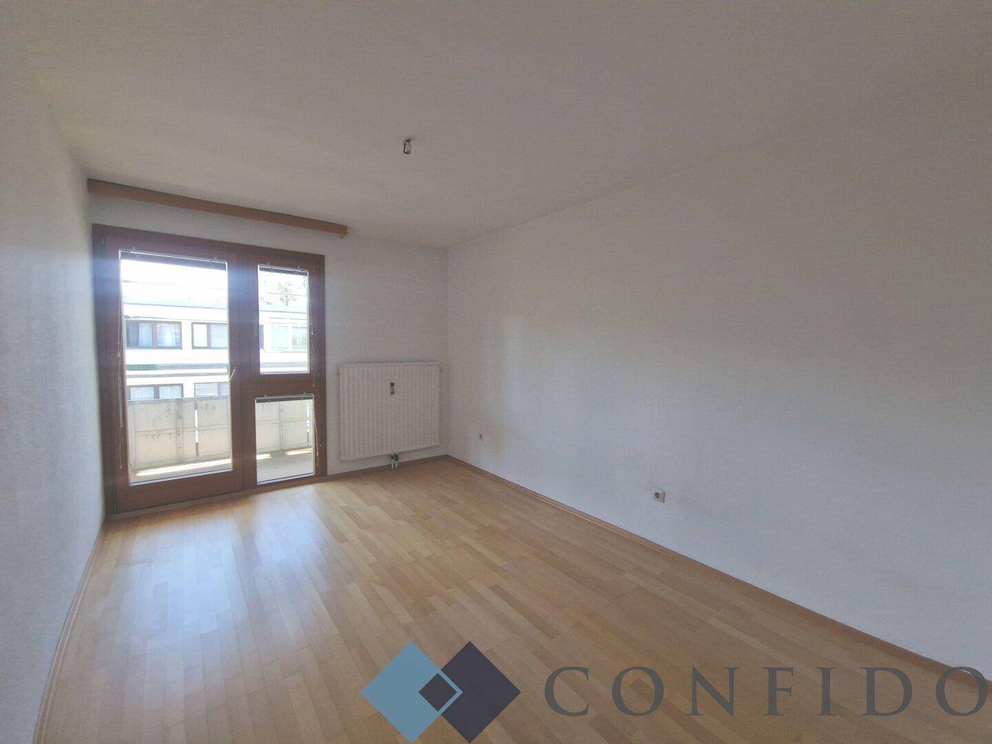 Helles Schlafzimmer mit Parkettboden und Fensterfront, ideal für individuelle Gestaltung.