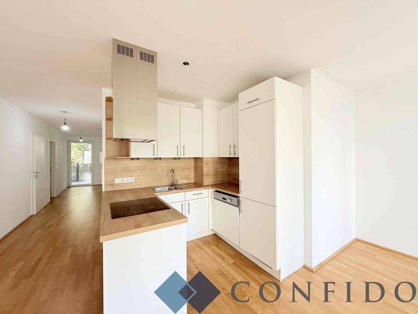 Moderne Einbauküche mit weißen Schränken, Holztheke und integrierten Geräten.