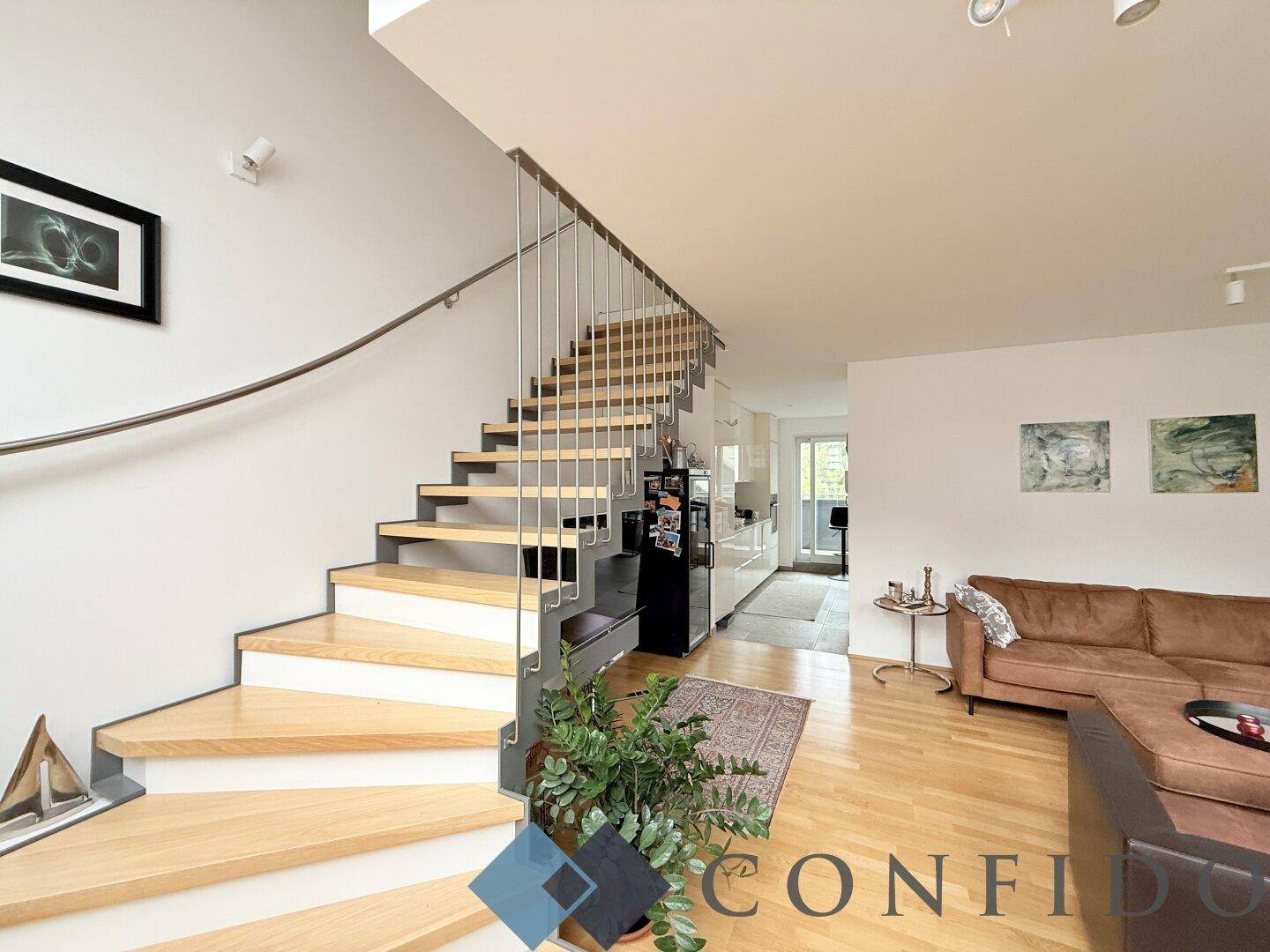 Moderne Holztreppe mit elegantem Metallgeländer, die die verschiedenen Ebenen der Wohnung verbindet.