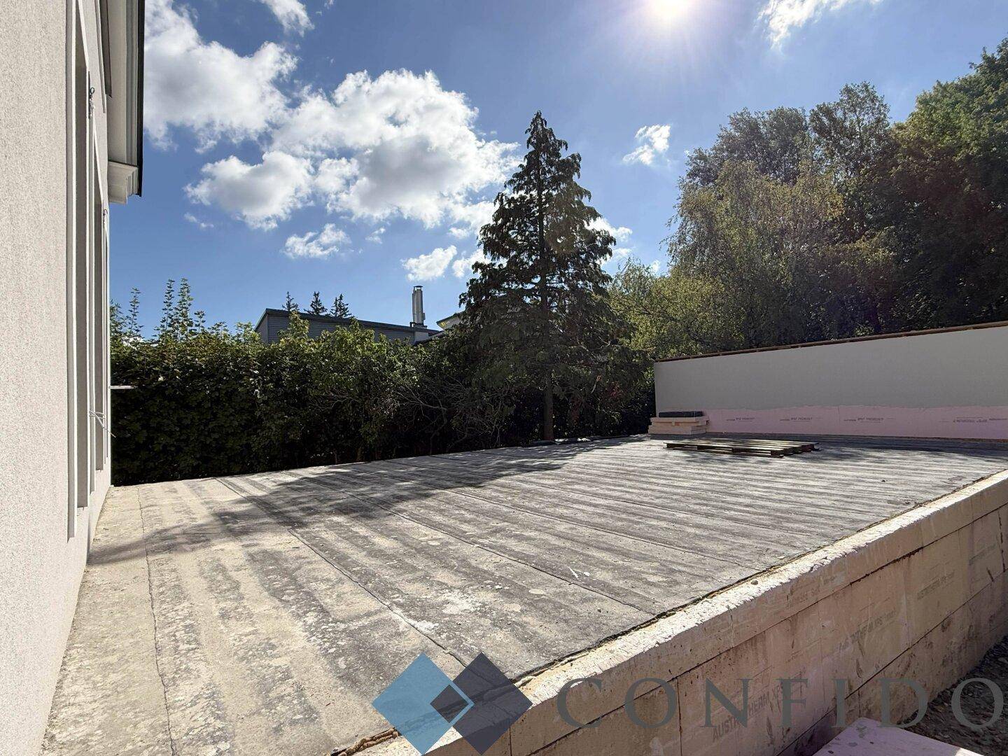 Unfertige Betonfläche, möglicherweise eine zukünftige Terrasse oder Dachterrasse, bei sonnigem Wetter.