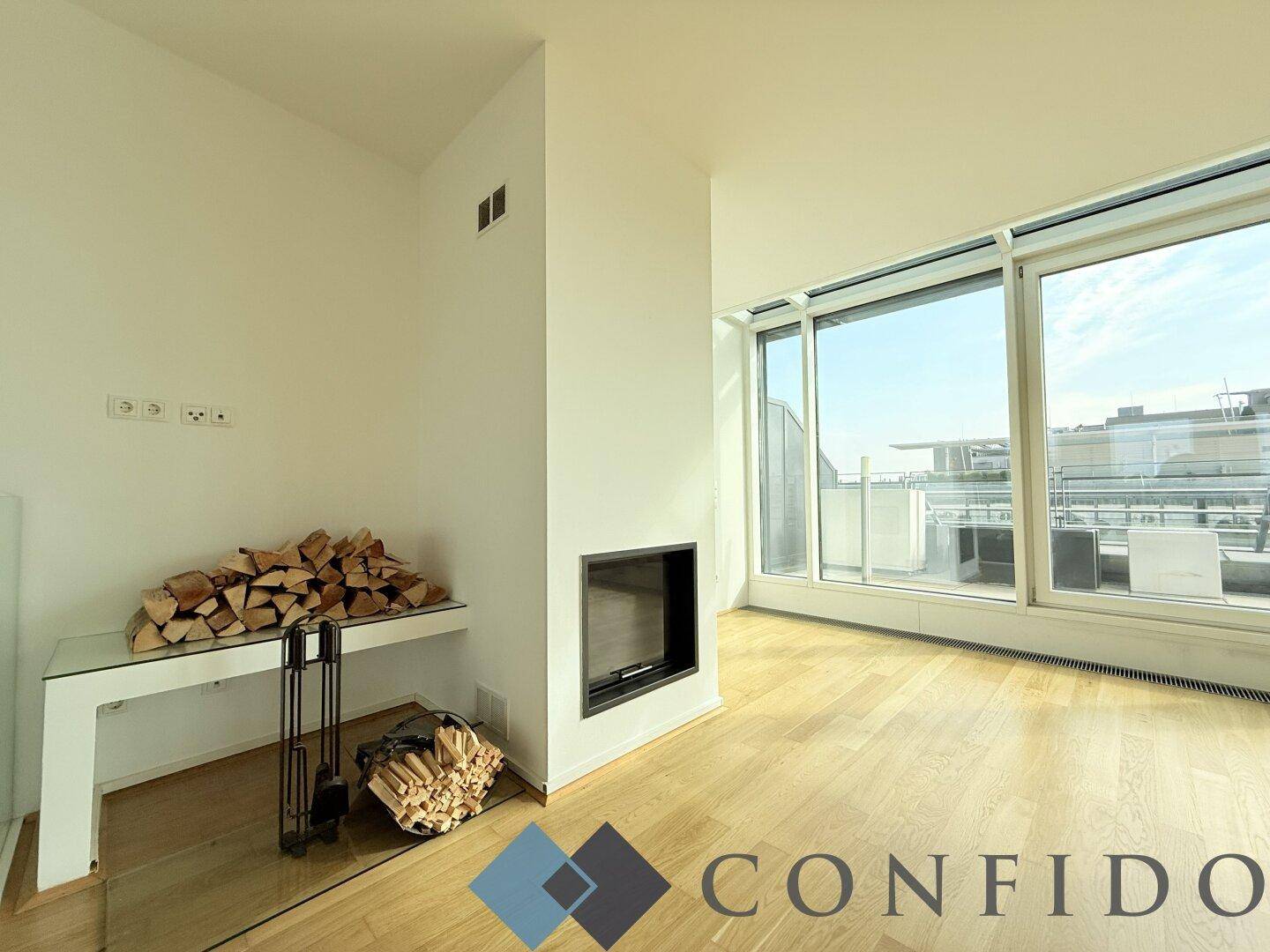 Gemütliche Ecke im Wohnzimmer mit modernem Kamin und großen Fenstern zur Terrasse.