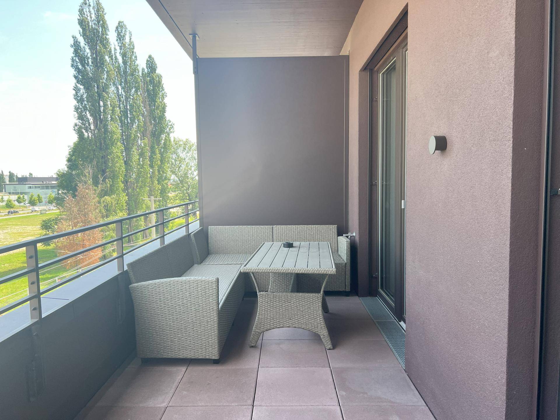 Gemütlicher Balkon mit Outdoor-Möbeln und weitem Blick ins Grüne.