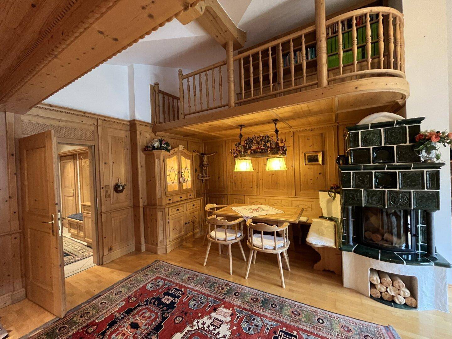 Essbereich im alpinen Stil mit Holztisch, Eckbank und traditionellem Kachelofen.