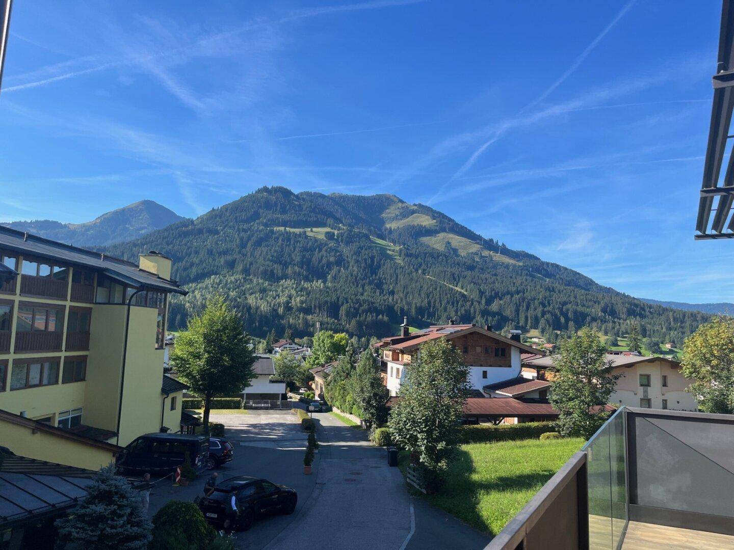 Panoramablick auf die Berglandschaft und das Dorf von einem Balkon aus.