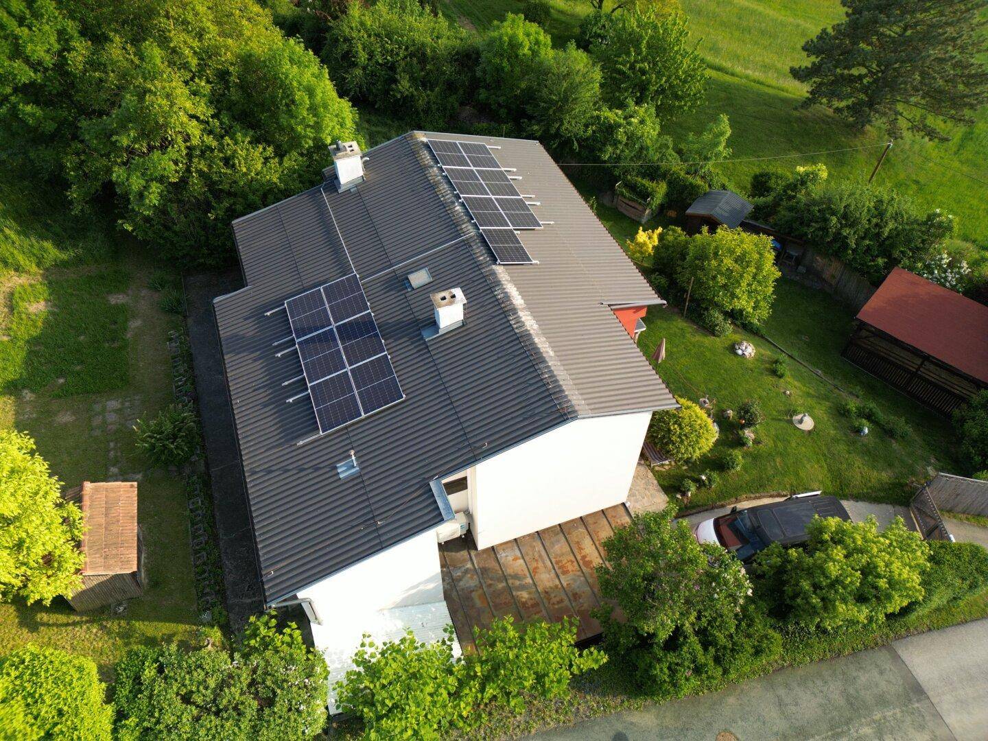 Dachansicht eines Hauses mit Photovoltaikanlage und grauen Dachziegeln.