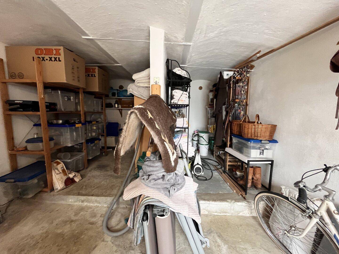 Kellerraum mit Regalen, Lagerboxen und einem Fahrrad, ideal für zusätzlichen Stauraum.