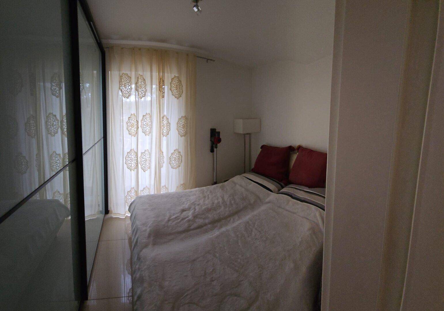 Gemütliches Schlafzimmer mit Fliesenboden und großem Kleiderschrank.