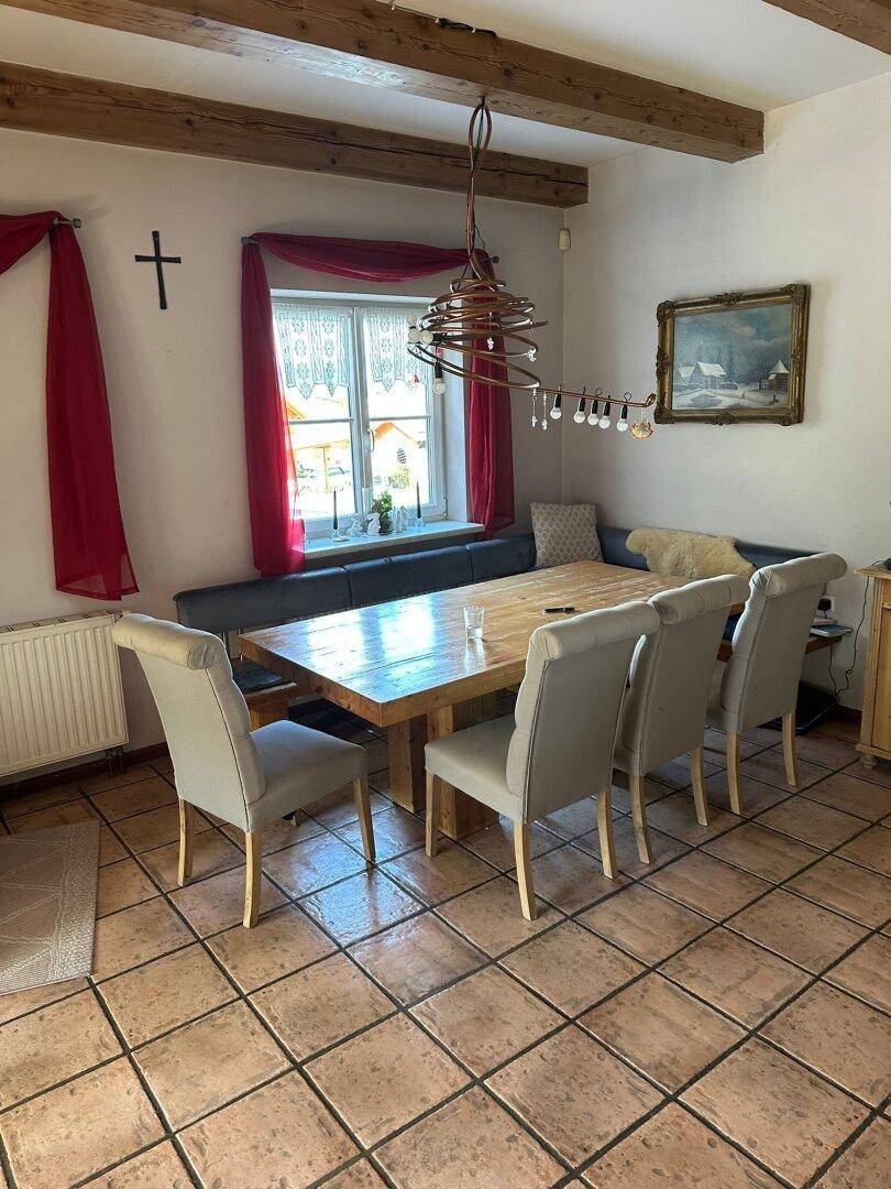 Gemütlicher Essbereich mit großem Holztisch, Eckbank und Terrakottafliesen, ideal für Familienessen.