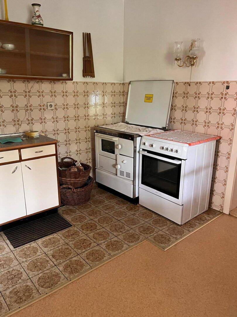 Küchenbereich mit zwei freistehenden Herden und traditionellen Wandfliesen im Landhausstil.
