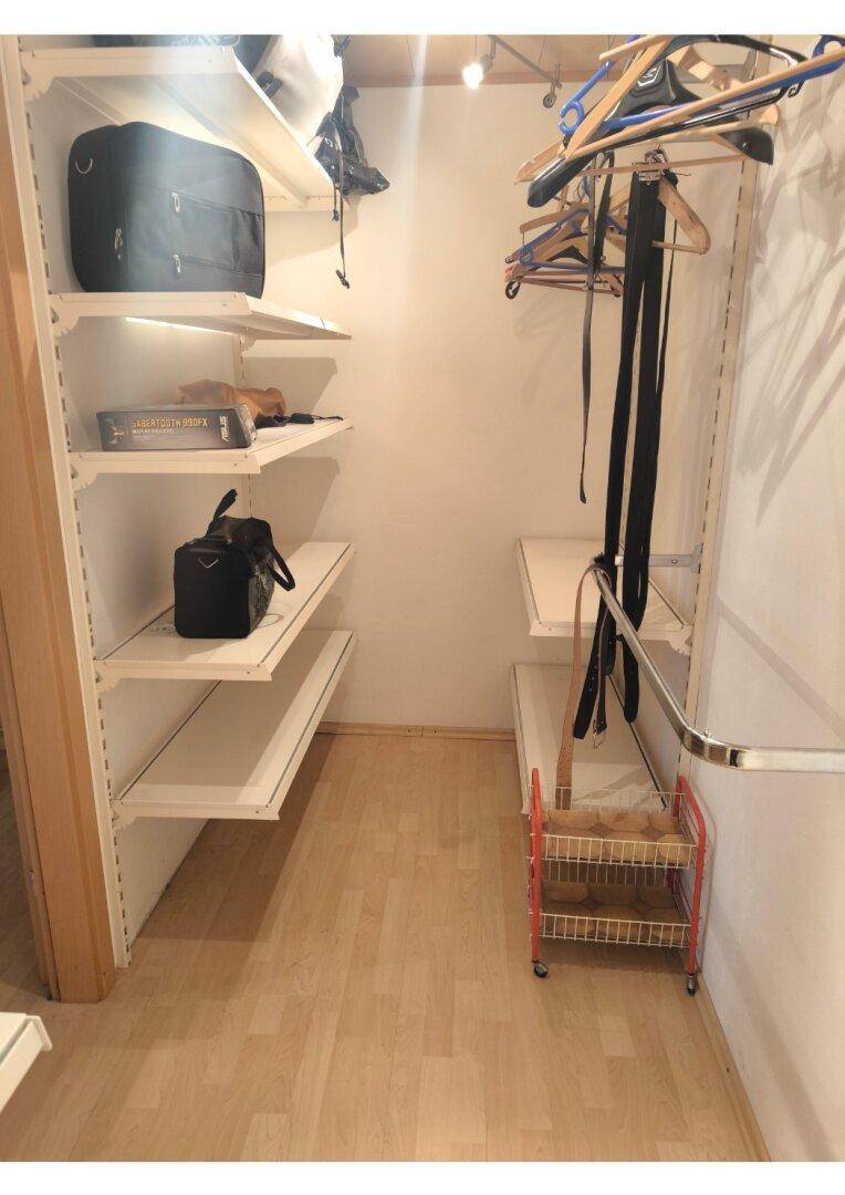 Begehbarer Kleiderschrank mit Regalen und Kleiderstangen, bietet viel Stauraum.