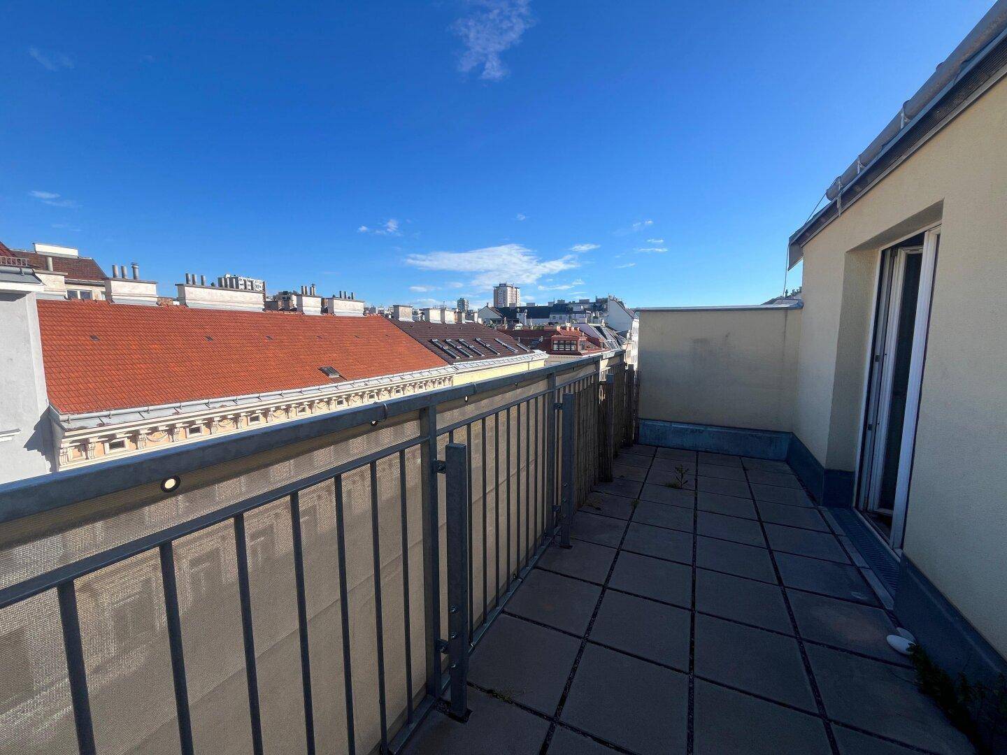 Geräumiger Balkon mit Fliesenboden und weitem Blick über die städtische Umgebung.