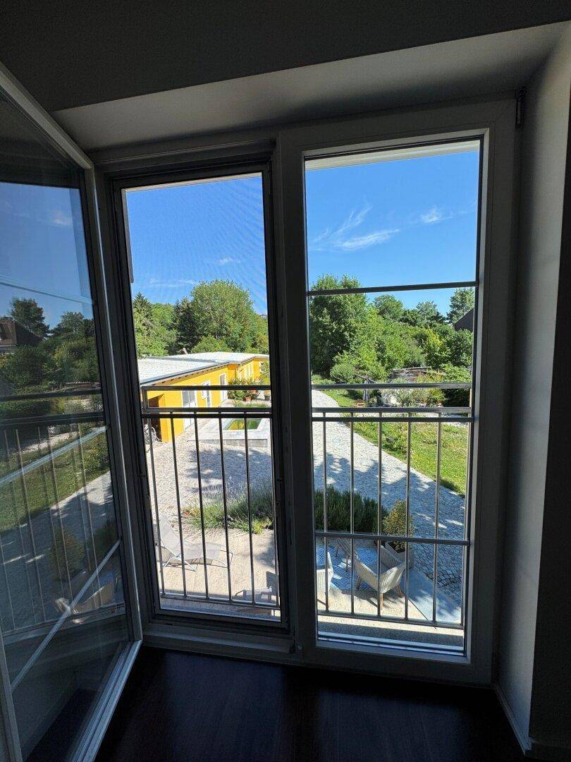 Blick von einem französischen Balkon auf den Außenbereich und die grüne Umgebung.