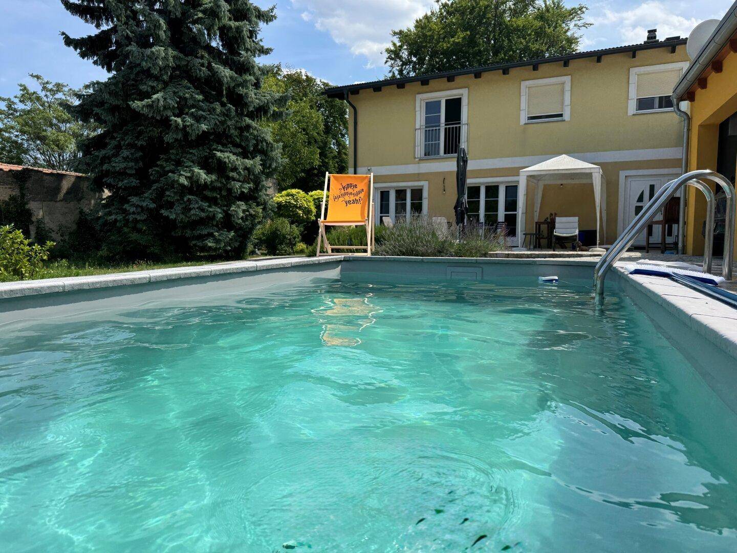 Erfrischender Swimmingpool im Gartenbereich mit Blick auf das Wohnhaus.