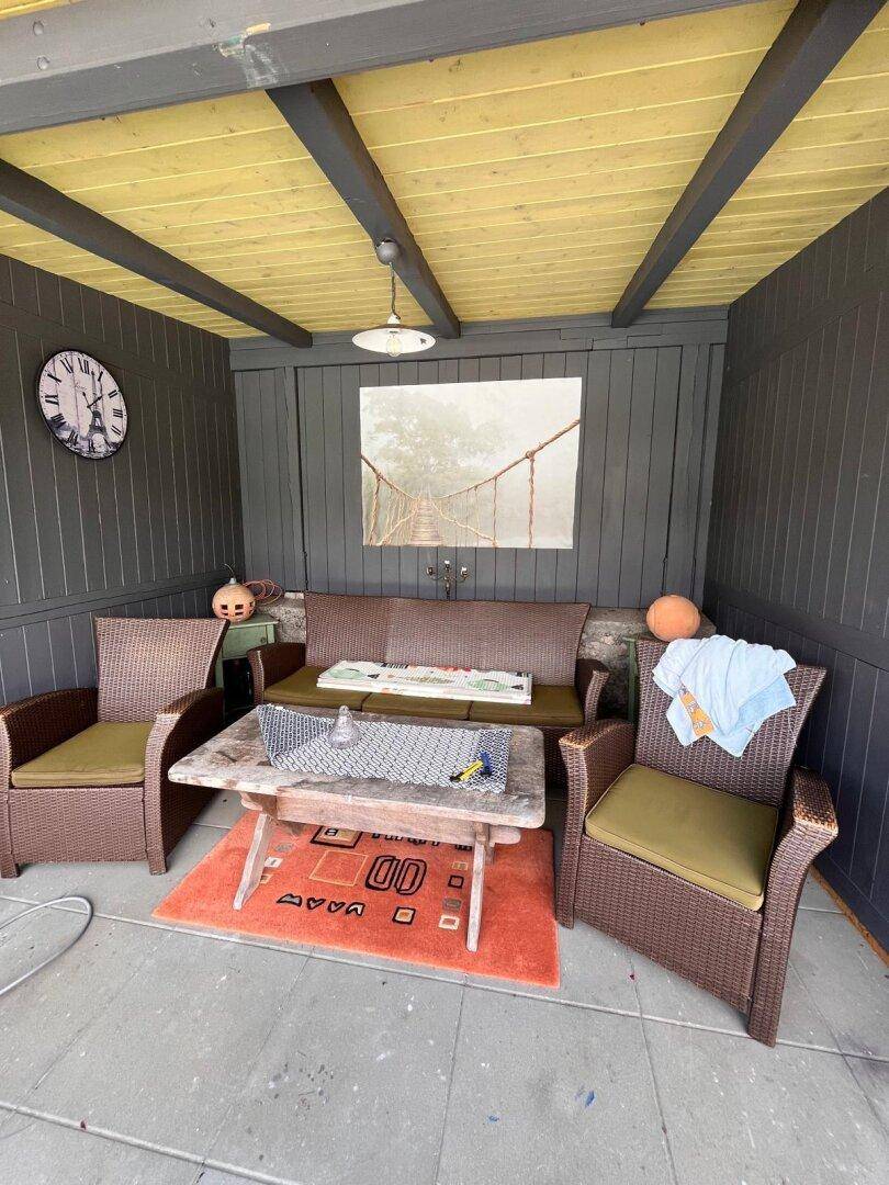 Gemütliche überdachte Terrasse mit Rattanmöbeln und einem Holztisch für entspannte Stunden.
