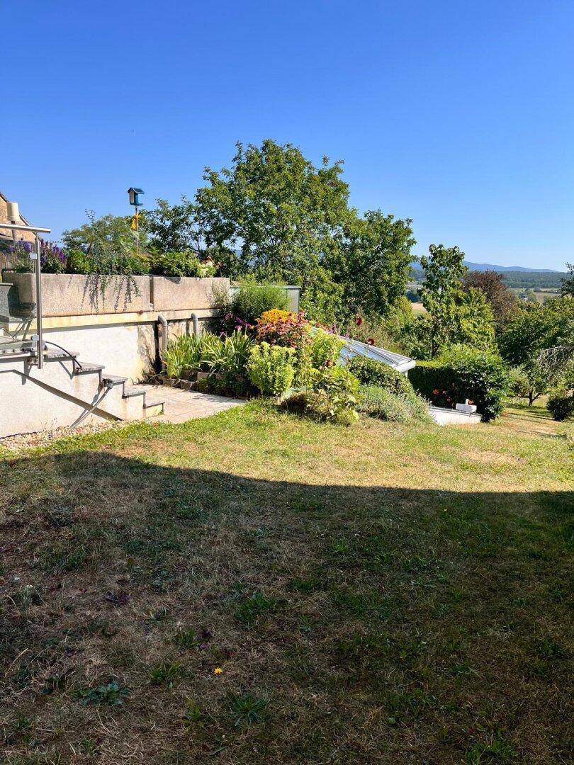 Weitläufiger Garten mit üppiger Bepflanzung und Panoramablick auf die Landschaft.
