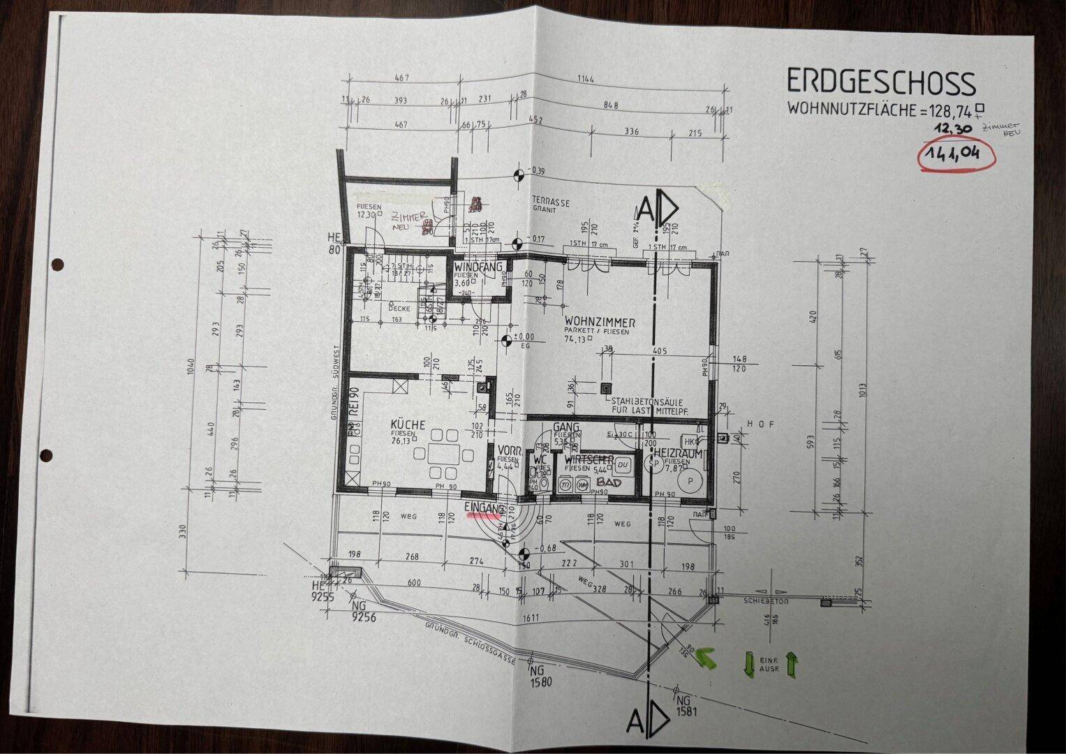 Grundriss des Erdgeschosses mit Wohnzimmer, Küche, Bad und Zugang zu einer Terrasse.