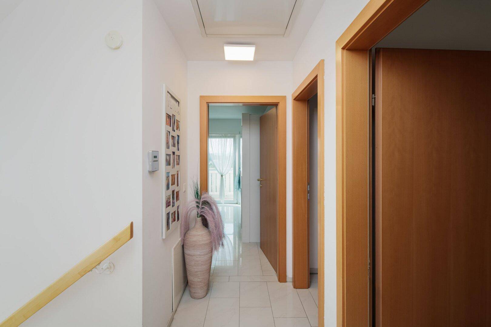 Heller Flur im Obergeschoss mit Zugang zu den Schlafzimmern und einem Dachbodenfenster.