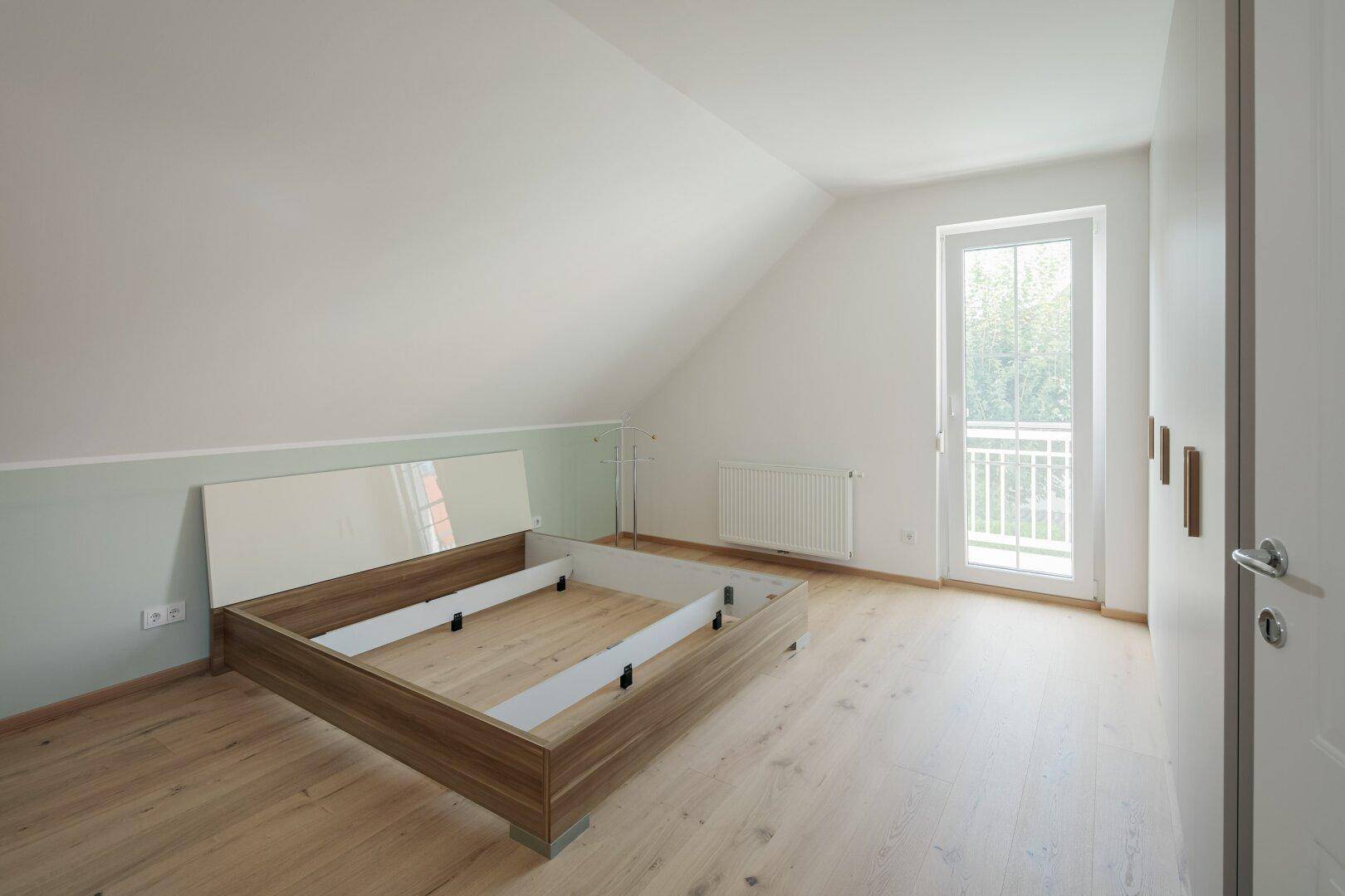 Schlafzimmer im Dachgeschoss mit Zugang zum südseitigen Balkon