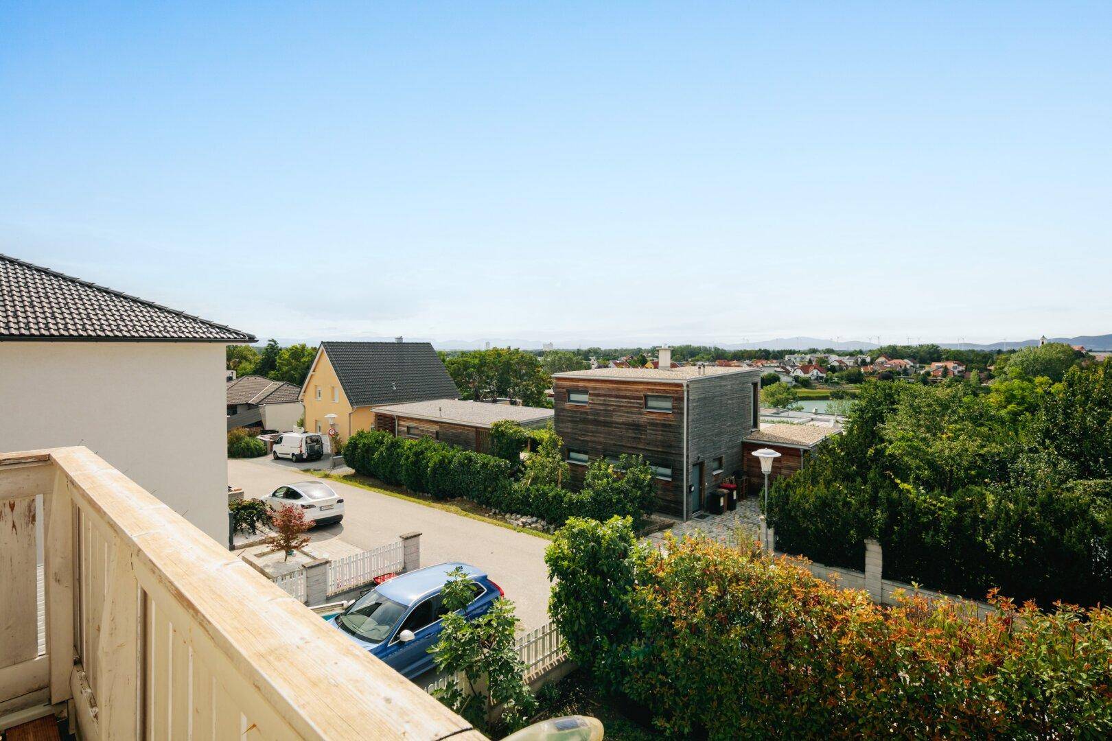 Weitläufiger Blick über die Nachbarschaft mit Häusern und grüner Landschaft vom Balkon aus.