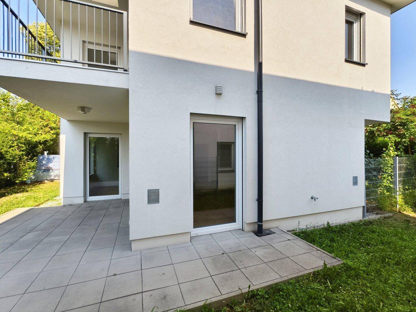 Rückansicht des Hauses mit Zugang zur Terrasse und Blick auf den kleinen Garten.