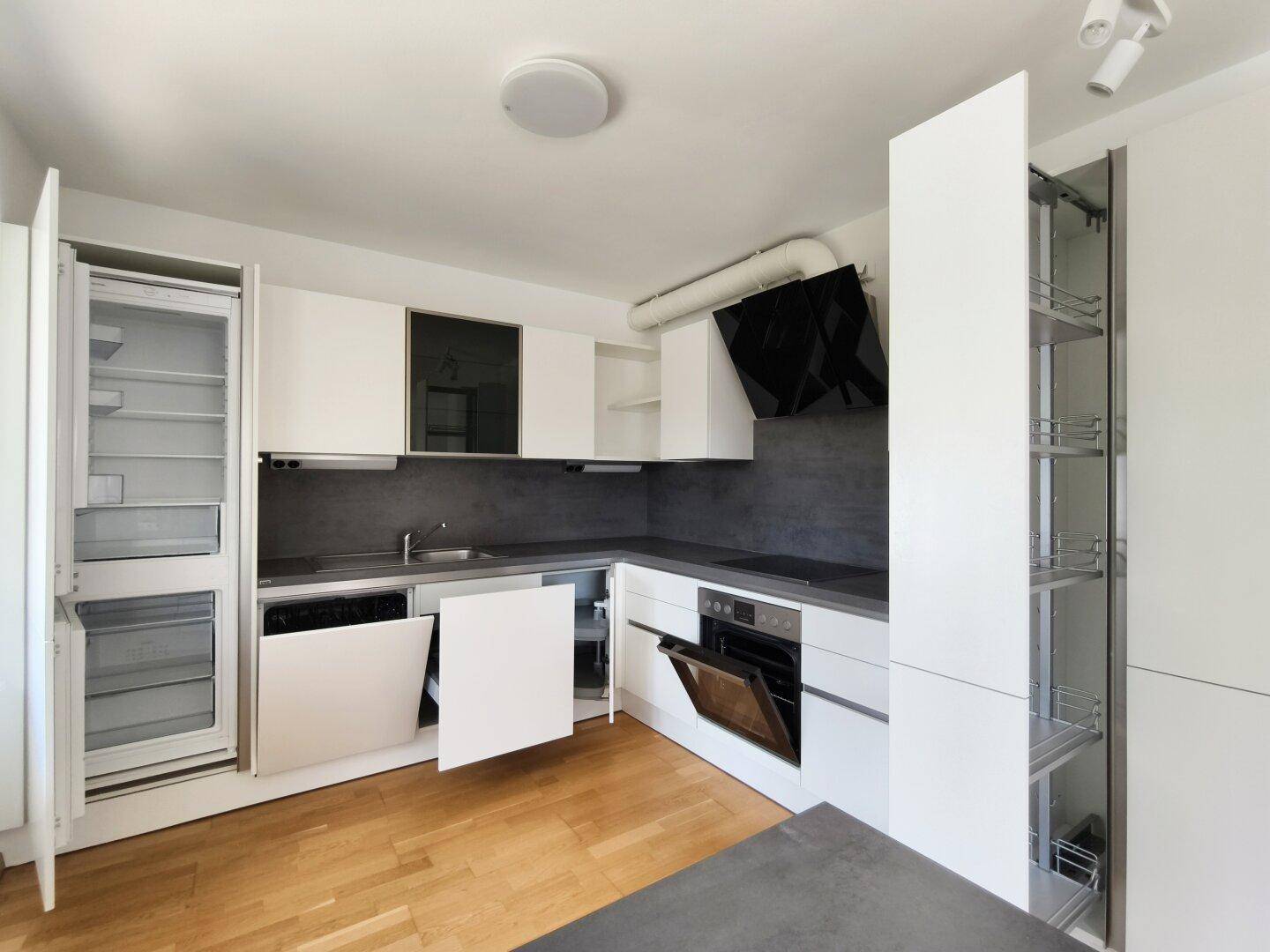 Funktionale Küche mit integriertem Kühlschrank, Geschirrspüler und praktischen Auszügen.