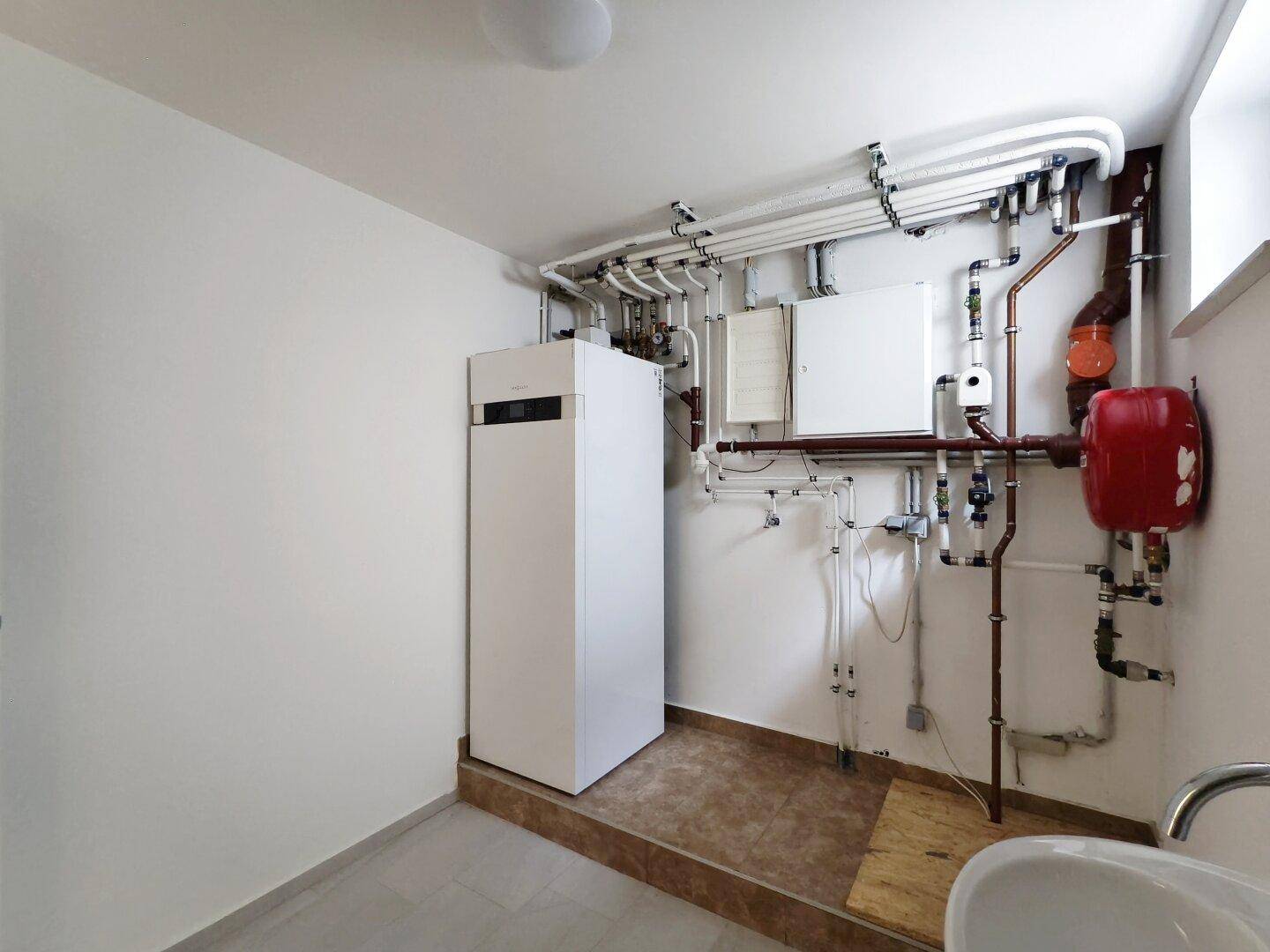 Heizungsraum mit moderner Anlage und zahlreichen Installationen an den Wänden.