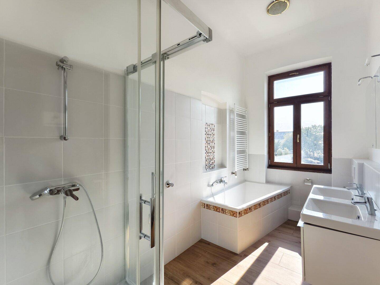 Modernes Badezimmer mit Dusche, Badewanne, Doppelwaschbecken und Fenster.