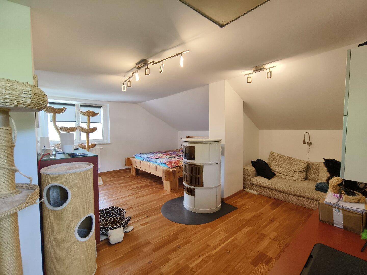 Geräumiges Schlafzimmer im Dachgeschoss mit Kachelofen und gemütlicher Sitzecke.