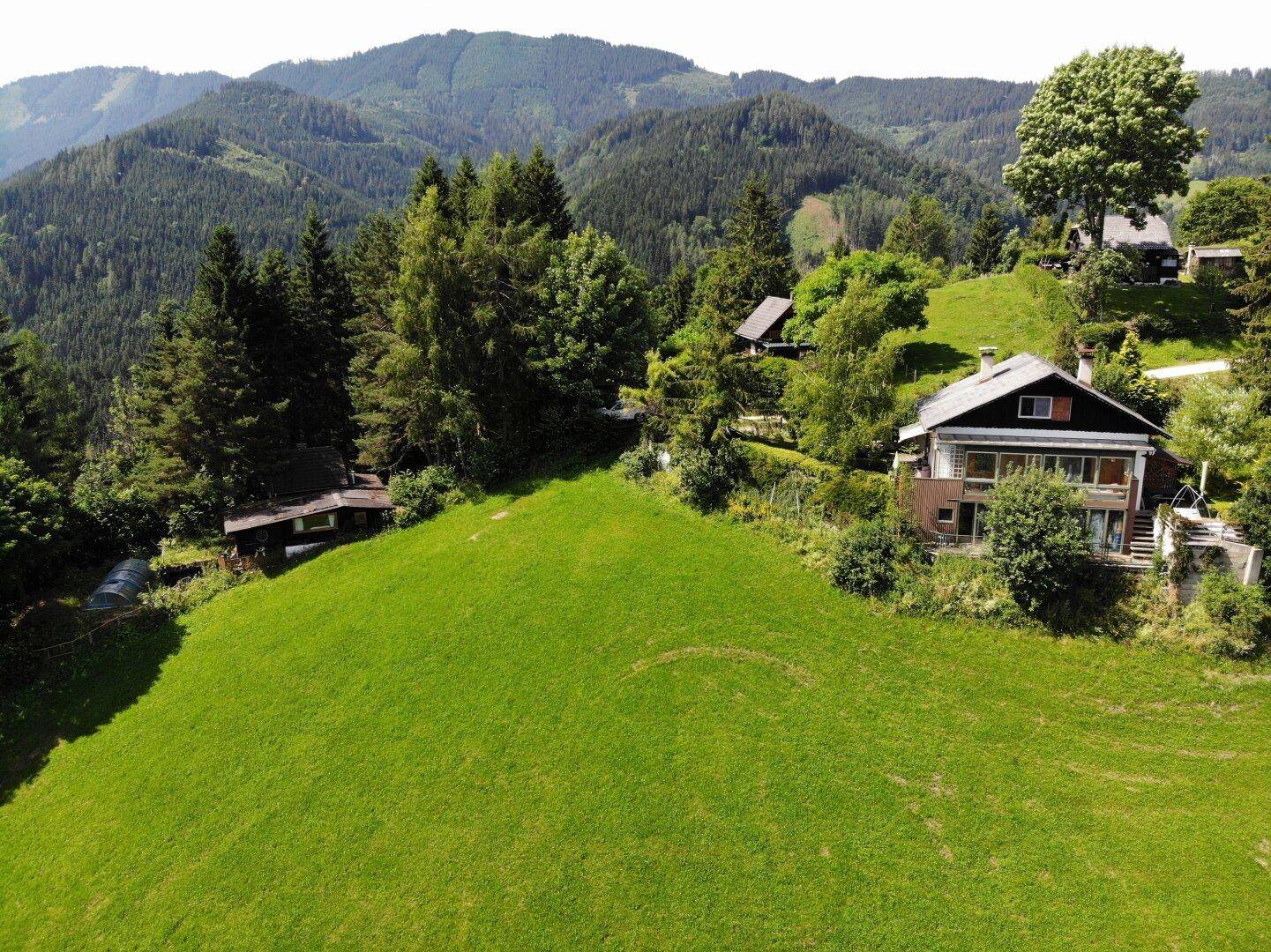 Panoramische Luftaufnahme des Hauses, eingebettet in die weite, grüne Naturlandschaft.