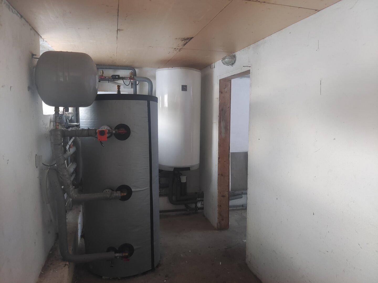 Technikraum mit Warmwasserspeichern und Heizungsanlagen für das Gebäude.