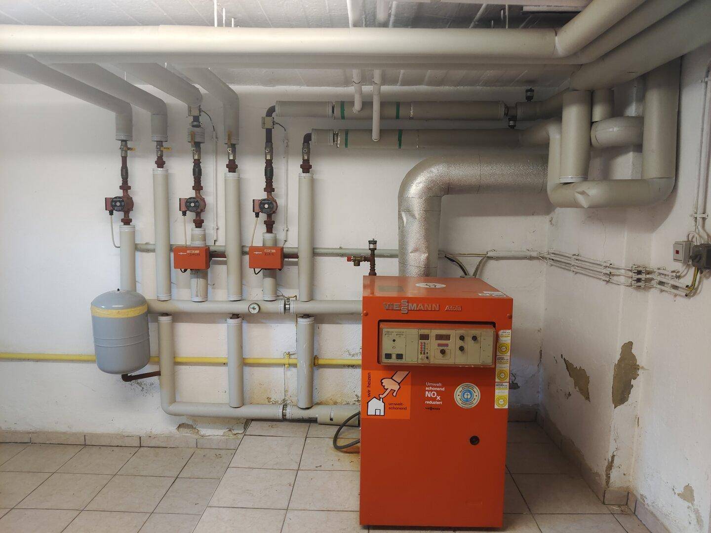Heizungsraum im Keller mit einem Viessmann Heizkessel und sichtbaren Rohrleitungen.