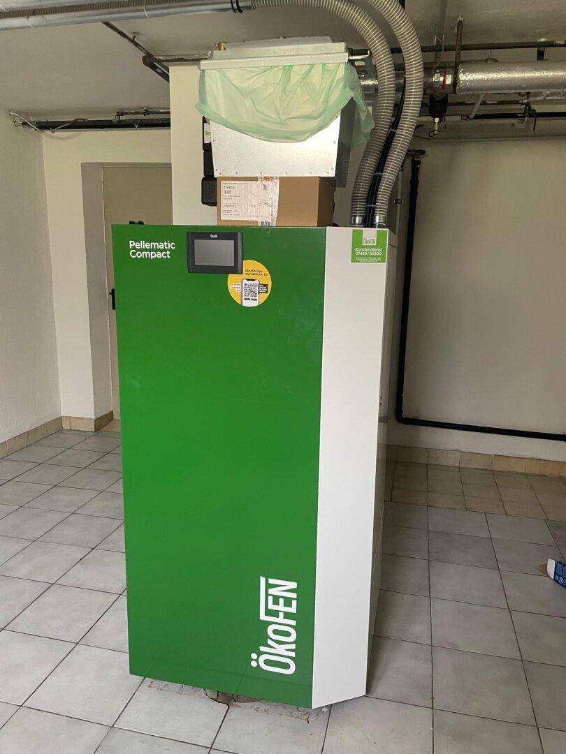 Moderner Pelletofen 'ÖkoFEN Pellematic Compact' in einem Technikraum für effiziente Heizung.
