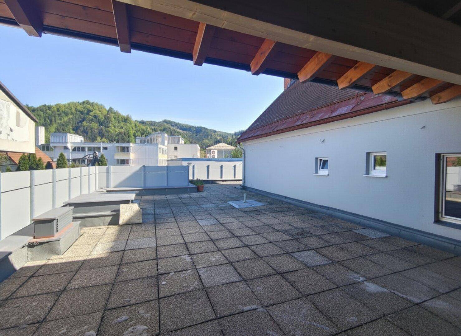 Große geflieste Terrasse mit Blick auf die umliegende Landschaft und Berge.