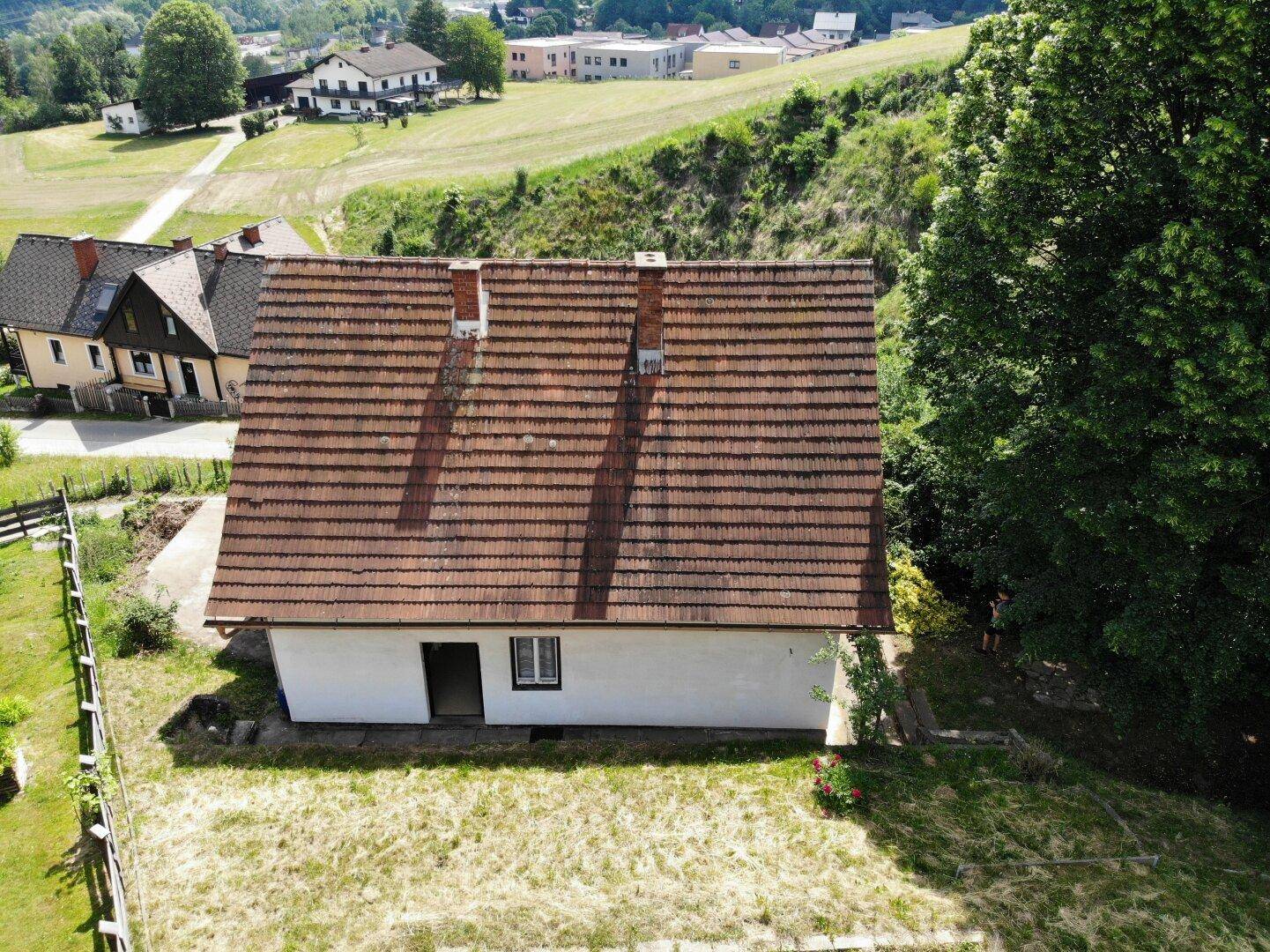 Dachansicht des Hauses mit Ziegeln und einem weitläufigen Gartenbereich.