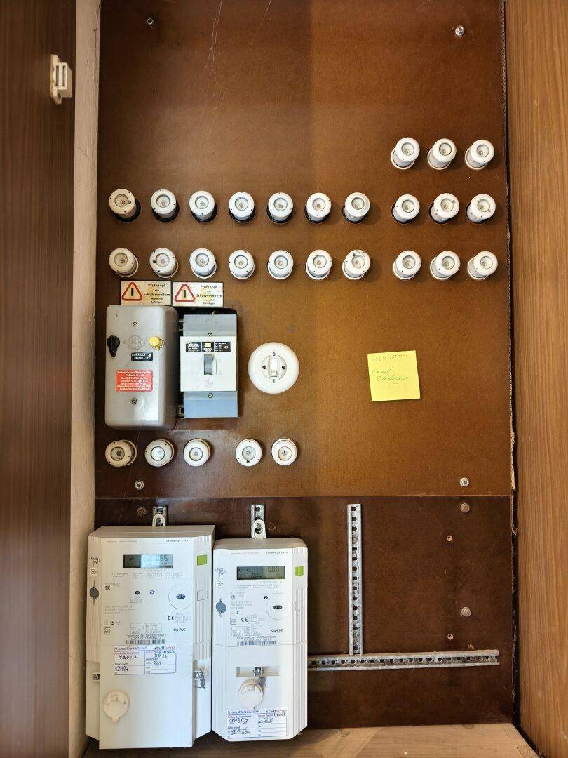 Elektrischer Sicherungskasten mit Zählern und vielen Sicherungen.