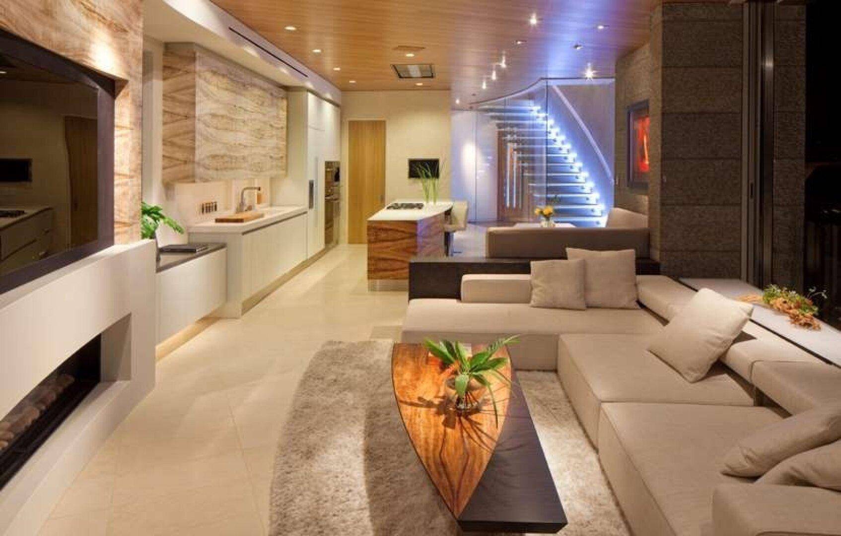 Geräumiger offener Wohnbereich mit moderner Küche, bequemen Sofas und eleganter Beleuchtung.