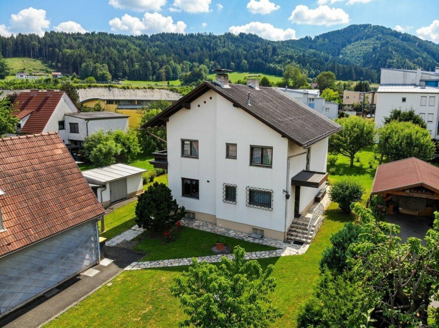 Ansicht des Hauses von der Rückseite mit gepflegtem Garten und Nebengebäude.