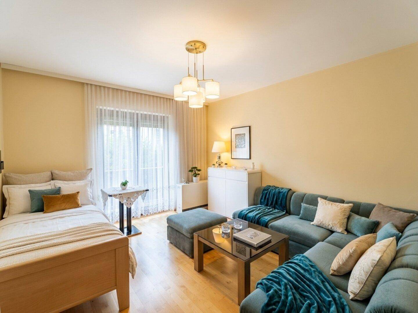 Helles Wohnzimmer mit Holzboden, beiger Wandfarbe, Sofa und einem Einzelbett.