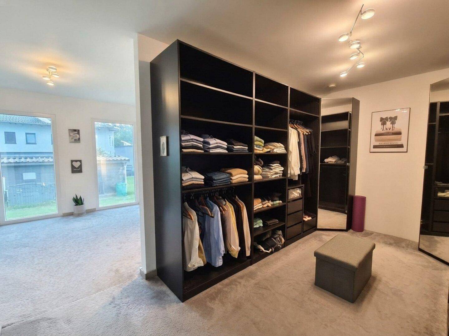 Gut organisierter begehbarer Kleiderschrank mit viel Stauraum und integrierten Regalen.