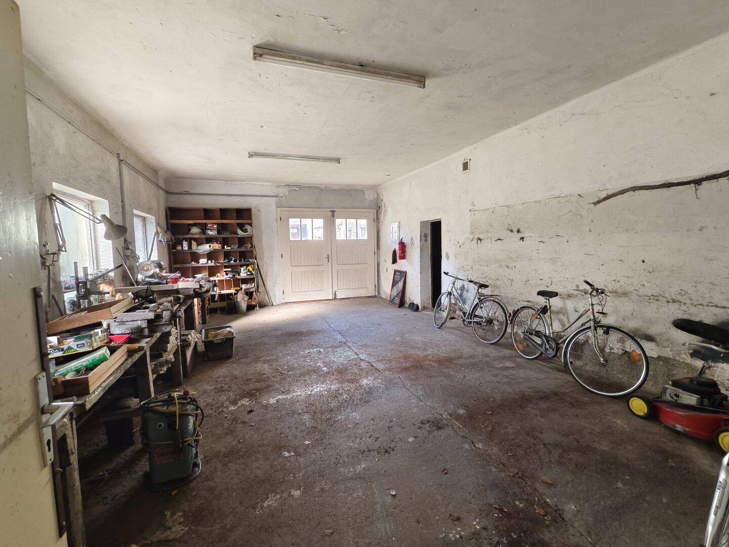 Geräumige Garage oder Werkstatt mit Betonboden, Doppeltoren und viel Platz.