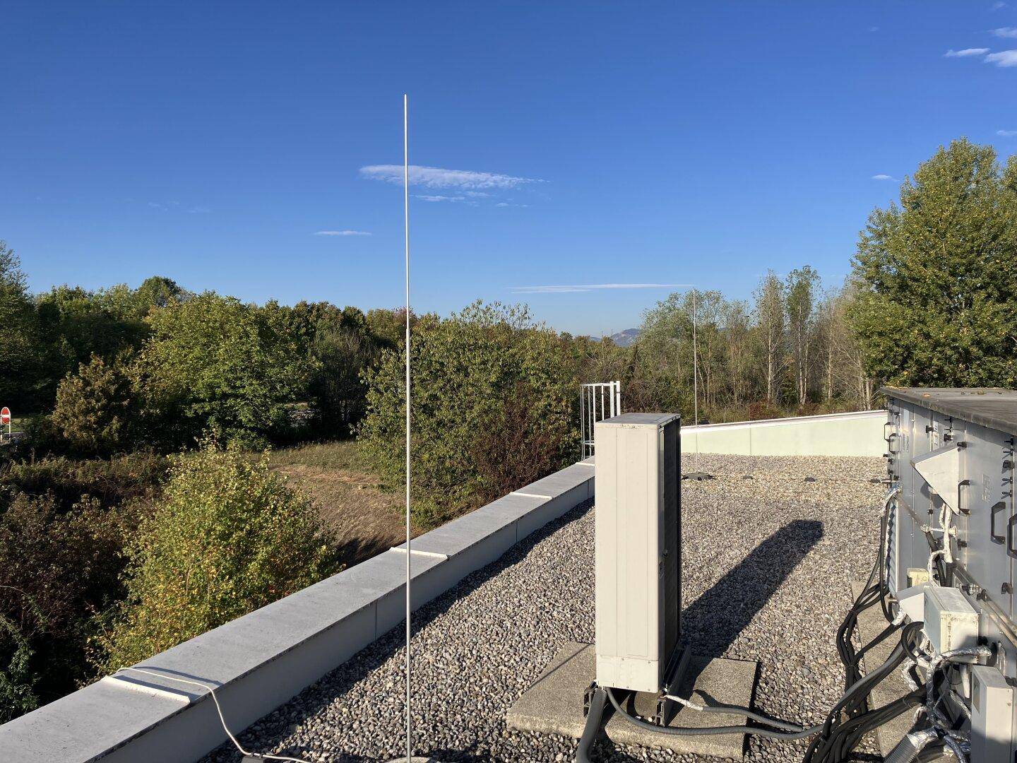 Aussicht vom Flachdach mit Blitzableiter, technischen Geräten und weitem Blick ins Grüne.