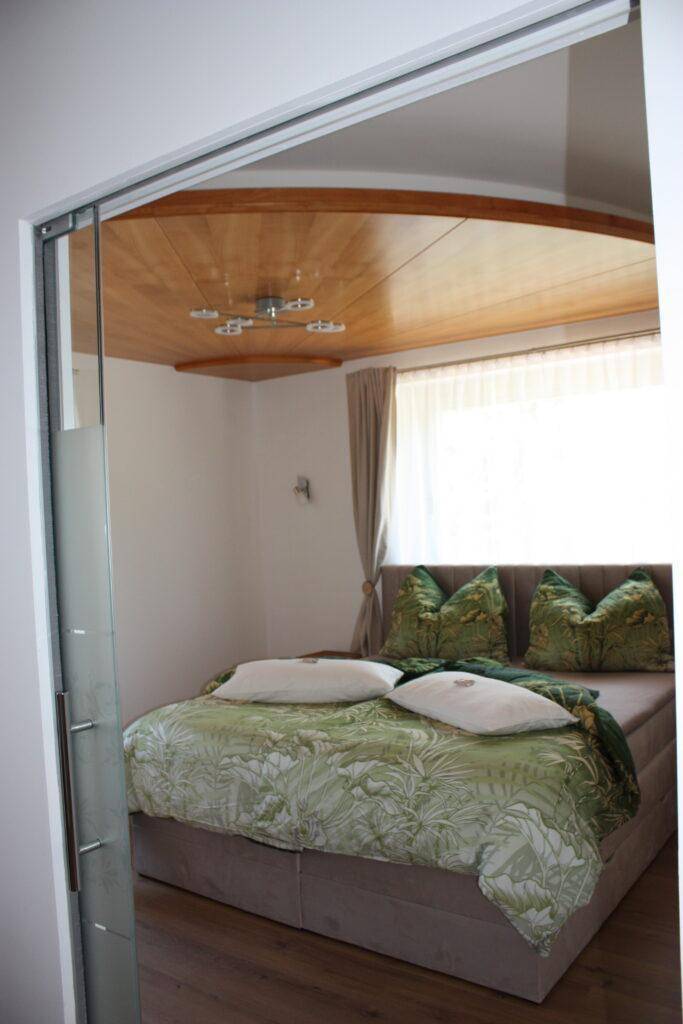Gemütliches Schlafzimmer mit Holzakzenten an der Decke und weichen Kissen, ideal zum Entspannen.