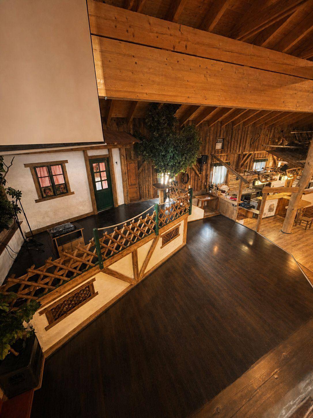 Großer Saal mit Bühne, Projektionsfläche und einem dekorativen Baum, der eine natürliche Atmosphäre schafft.